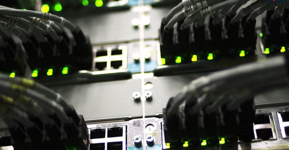 Comdiel_img_2 | Atwix Comdiel Network Switches with Multiple Connected Ethernet Cables and Glowing Green Status Lights in a Data Center.