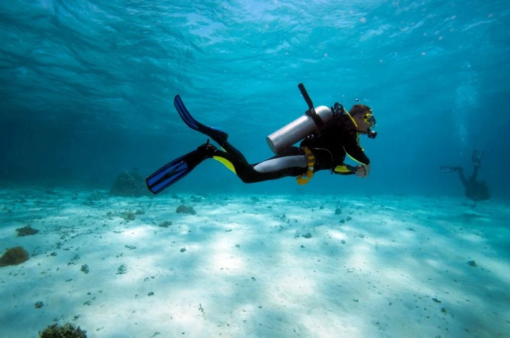 Diver in Shallow Water | Atwix Scuba Diver Exploring the Ocean Floor with Dive Gear Express Equipment, Showcasing Premium Diving Gear.